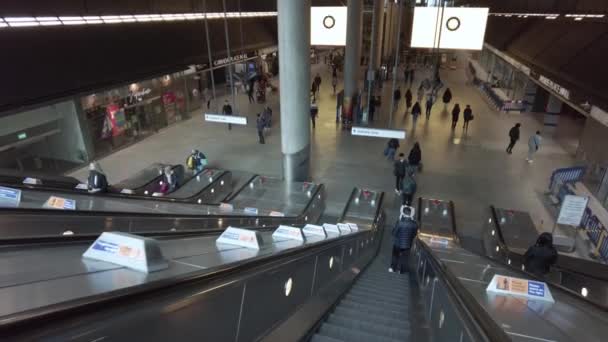 Går ner för rulltrappan vid upptagen Canary Wharf tunnelbanestation — Stockvideo