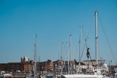 Ramsgate, Kent (124; İngiltere - 2021.05.29: Ramsgate 'deki Yacht Marina' da yelkenli teknesinin direğinde çalışan erkek