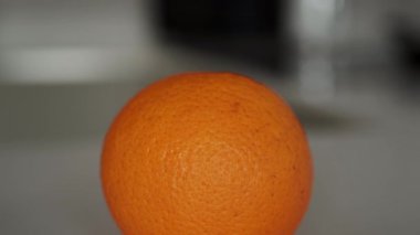 Beyaz mutfak tezgahındaki tek bir portakalın görüntülerini büyüt.