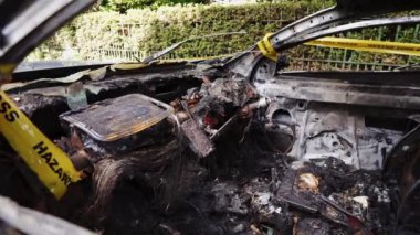 Terk edilmiş, çalıntı mavi bir arabanın içinde yan park yerine park edilmiş. Sarı şeritle bağlanmış.