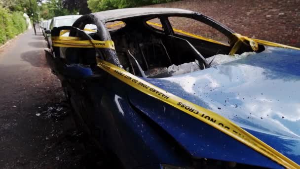 Opuštěné, odcizené, vyhořelé modré auto zaparkované na postranním parkovišti svázané žlutými pruhy nepřejíždějí — Stock video