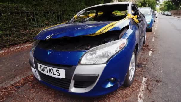 Заброшенная, украденная выжженная синяя машина, припаркованная на боковом парковочном месте, связанная желтым, не пересекает полосу — стоковое видео