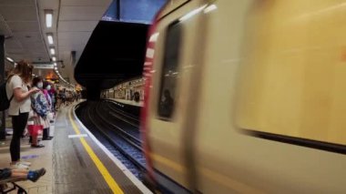 Maskeli insanlar yaz günü Victoria İstasyonu 'nda tren bekliyor.