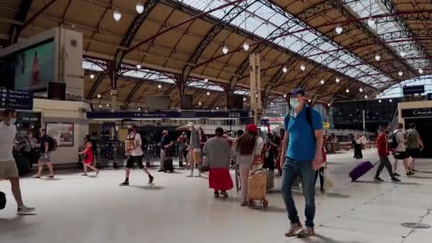 Persone che indossano maschere passeggiando per la trafficata zona della stazione di Londra Victoria nelle calde giornate estive — Video Stock
