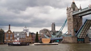 Arka planda Tower Köprüsü açıkken Thames Nehri 'nde yüzen Burberry Olympia çantası.