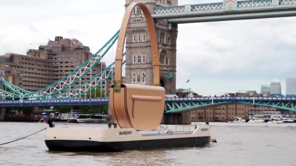 Burberry Olympia bag floating down the Thames River with the Tower Bridge in the background — Stock Video