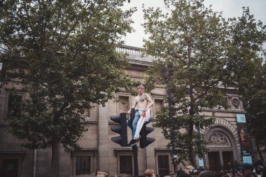 Londra (124; İngiltere - 2021.07.12: Genç İngiliz futbol taraftarı Trafalgar Meydanı 'ndaki trafik ışığının tepesinde gömleksiz oturuyor