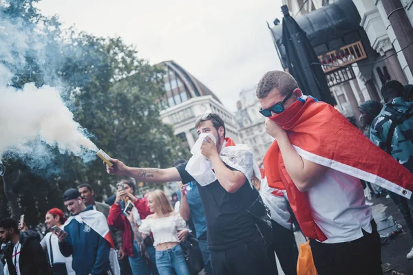 stock image London | UK - 2021.07.12: Young English Euro 2020 football fans burning smoke granades in central London