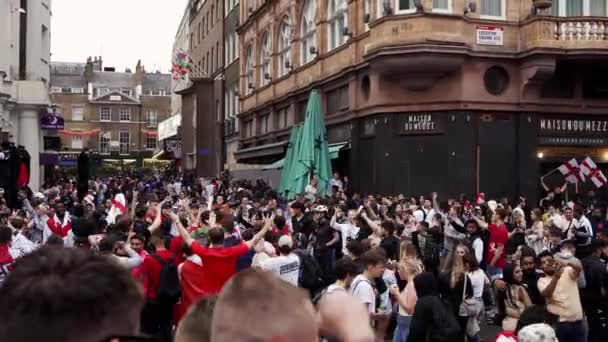 Aficionados ingleses con banderas se reúnen en Leicester Square para ver el juego Final Euro 2020 Football — Vídeo de stock