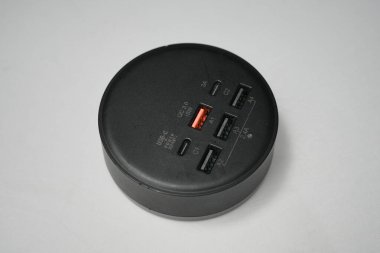 Londra, Birleşik Krallık 2025.10.16 QC 3.0 hızlı şarj seçeneği de dahil olmak üzere birden fazla USB-A ve USB-C portlarının bulunduğu siyah dairesel bir USB 'nin yakın çekimi. 