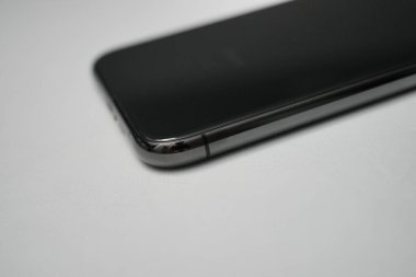 Londra, Birleşik Krallık 2025.10.16 Apple iPhone XS 'nin beyaz bir yüzeye yerleştirilmiş gri renkli arka görüntüsü, çift kamerayı ve yansıtıcı cam tasarımı gösterir. 