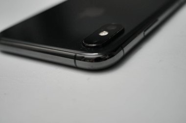 Londra, Birleşik Krallık 2025.10.16 Apple iPhone XS 'nin beyaz bir yüzeye yerleştirilmiş gri renkli arka görüntüsü, çift kamerayı ve yansıtıcı cam tasarımı gösterir. 