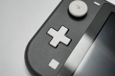 Londra, Birleşik Krallık 2025.10.16 Grey Nintendo Switch Lite el kumandalı oyun konsolu beyaz bir yüzeye yerleştirilir, parçalar veya tamir için gösterilir. 