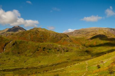 Snowdonia, Galler 2025.09.21 Snowdon tepelerinin geniş panoramik manzarası ve dağınık mavi bulutların altında yeşil bir vadi.. 
