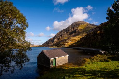 Snowdonia, Galler 2025.09.21 Stone kayıkhanesi. Llyn Ogwen 'in yeşil kapısı var. Güneşli Tryfan dağının altında mavi gökyüzü ve bulutların altında.. 