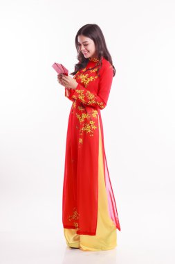 Kırmızı ao dai için şanslı kırmızı paketlerden tutan güzel Vietnamca kadınla ay yeni yıl kutlamak