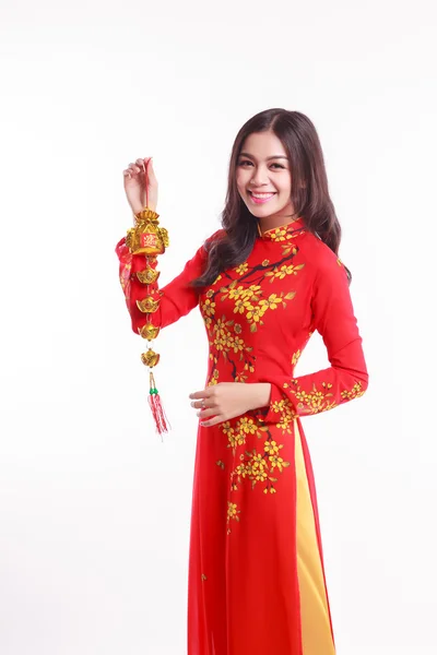 Mulher vietnamita bonita com vermelho ao dai segurando afortunado decorar objeto para comemorar o ano novo lunar — Fotografia de Stock