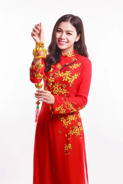 Mulher vietnamita bonita com vermelho ao dai segurando afortunado decorar objeto para comemorar o ano novo lunar — Fotografia de Stock