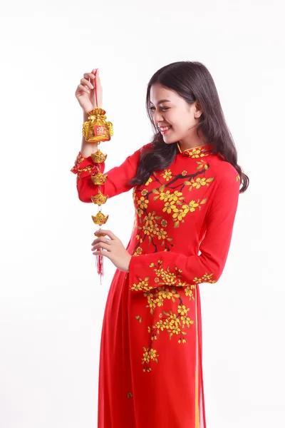 Beautiful Vietnamese woman with red ao dai holding lucky decorate object for celebrate lunar new year — Stock Photo, Image