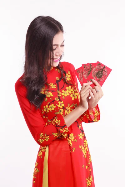 Vackra vietnamesiska kvinna med röda ao dai holding lucky röda paket för fira nyåret — Stockfoto
