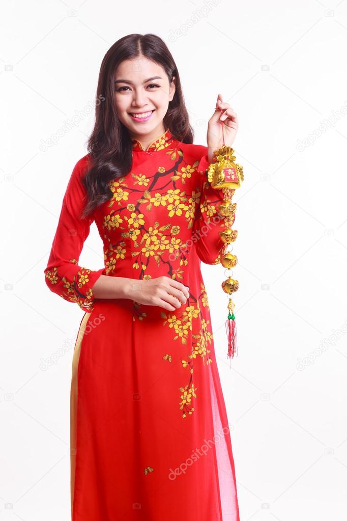 Beautiful Vietnamese woman with red ao dai holding lucky decorate object for celebrate lunar new year