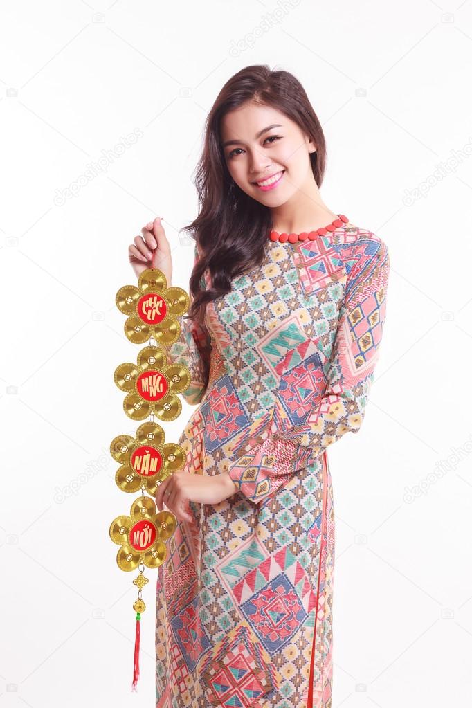 Beautiful Vietnamese woman wearing impression ao dai holding lucky decorate object for celebrate lunar new year