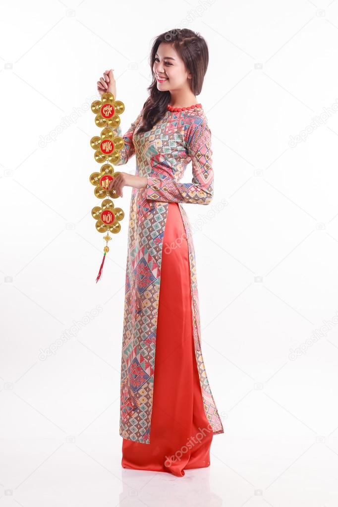 Beautiful Vietnamese woman wearing impression ao dai holding lucky decorate object for celebrate lunar new year