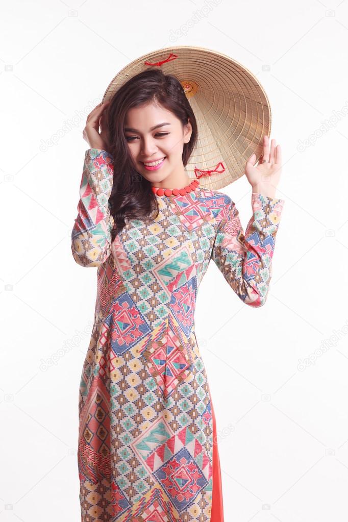 Beautiful Vietnamese young woman with tradition modern ao dai and palm-leaf conical hat