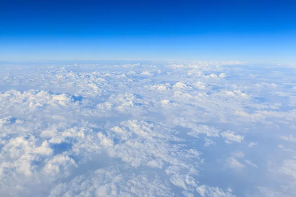 Błękitne niebo i chmury białe tło z okna samolotu — Zdjęcie stockowe