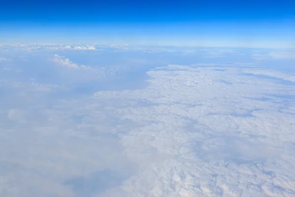 Blå himmel och vita moln bakgrund från flygplan fönster — Stockfoto