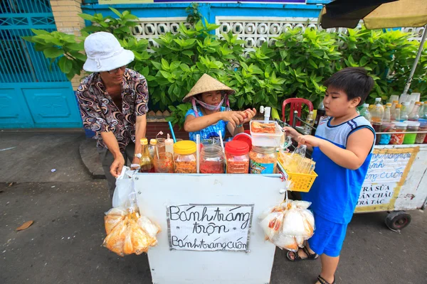 Los vendedores ambulantes que venden comida mezclan la torta. Los vendedores ambulantes son muy comunes en las calles de Vietnam . — Foto de Stock