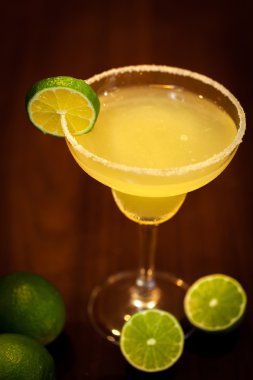 Koyu ahşap arka plan ile limon kokteyl içer