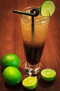 Koyu ahşap arka plan ile limon kokteyl içer