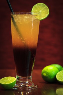 Koyu ahşap arka plan ile limon kokteyl içer