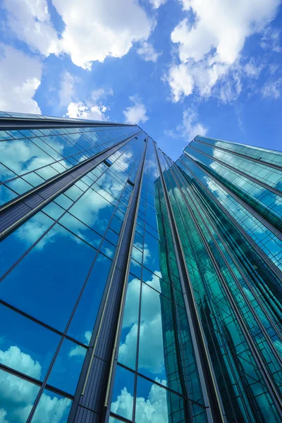 Mavi cam bina yansıtan gökyüzü ve bulutlar — Stok fotoğraf