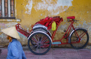 A women passing on Cyclos human transportation, Saigon, Vietnam. traditional hiring vehicle for city tour in vietnam that let passenger sit in the front of the driver