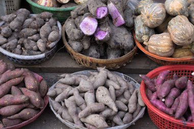 Background of sweet potato, potato, ginger, onion and others at local street market, Saigon, Vietnam.