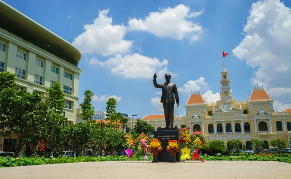 Новая статуя Хо Ши Мина с цветами вокруг перед зданием Народного комитета в Хо Ши Мине, внутри пешеходной улицы Нгуен . — стоковое фото