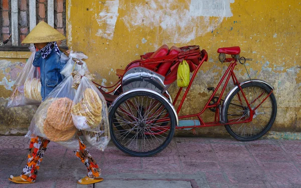 Vendedor ambulante pasando Cyclos transporte humano, Saigón, Vietnam. vehículo de alquiler tradicional para el recorrido por la ciudad en Vietnam que permiten a los pasajeros sentarse en la parte delantera del conductor —  Fotos de Stock