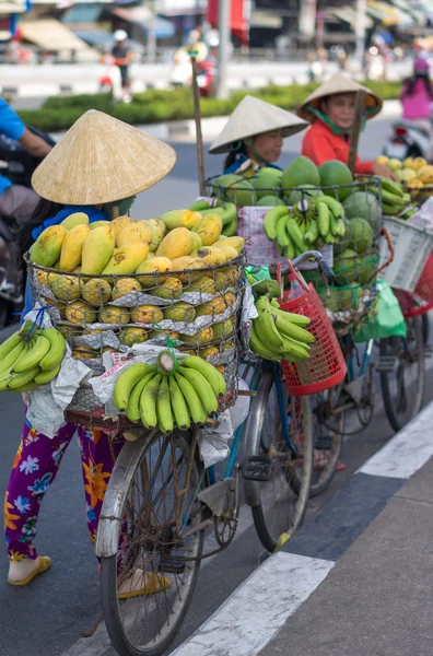 Tipico venditore di frutta di strada con cappello conico a foglia di palma che si muove per strada in strada . — Foto Stock