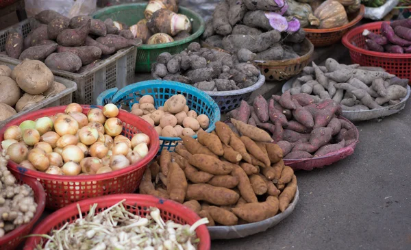 Latar belakang ubi jalar, kentang, jahe, bawang bombay dan lain-lain di pasar jalanan setempat, Saigon, Vietnam . — Stok Foto