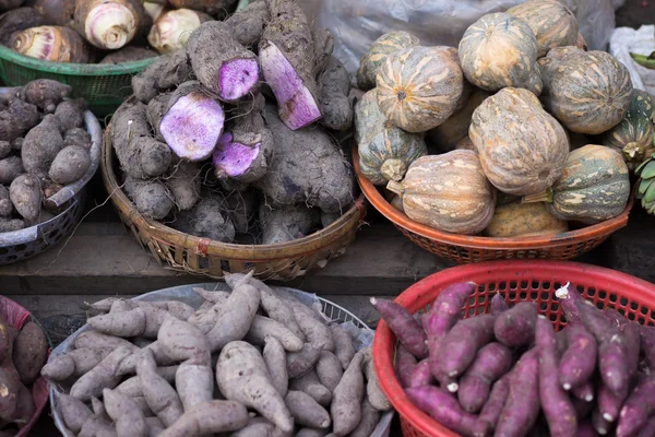 Latar belakang ubi jalar, kentang, jahe, bawang bombay dan lain-lain di pasar jalanan setempat, Saigon, Vietnam . — Stok Foto