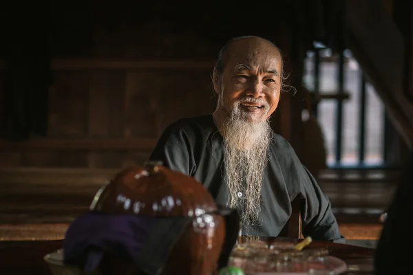 El anciano con traje negro tradicional, barba blanca dibujo caligrafía antigua distich en Long Son, Ba Ria Vung Tau, Vietnam a la celebración de año nuevo lunar que viene . —  Fotos de Stock