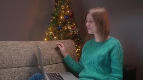 Різдвяна ніч, жінка розмовляє з батьками на блокноті, конференц-дзвінок, щоб відсвяткувати новий рік з друзями на карантині . — стокове відео
