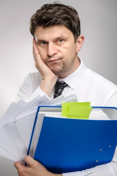 Man with lot of documents, worker of the month with thinking face expression. Office clerk in white shirt preparing for a presentation.