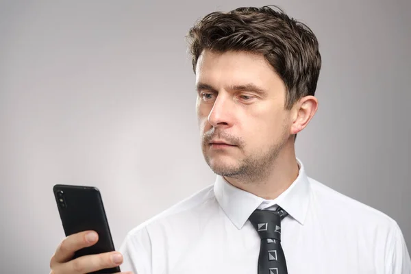 白いシャツのビジネスマンとネクタイ彼のスマートフォンを見て、メールでメッセージを読むために。会社労働者計画会議 ストック写真