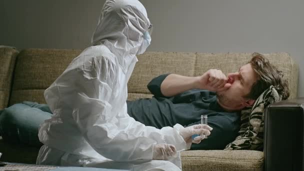 女性で保護衣装と顔マスク取ります上のテストでコロナウイルスに患者の家. — ストック動画