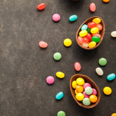 Karatahtanın üzerinde renkli şekerlemeler olan Paskalya çikolatası yumurtaları yaklaşan baharın sembolü..