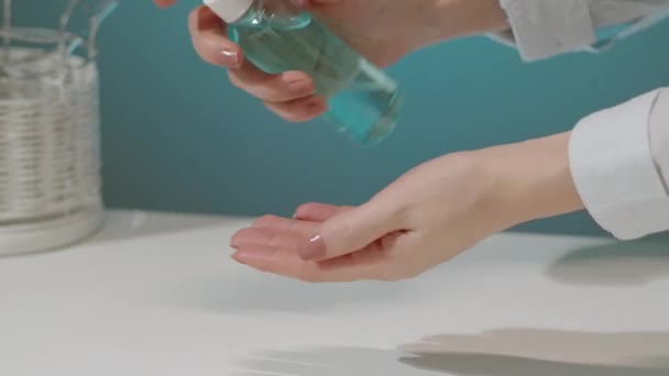Kadın elleri bir şişe sıvı dezenfektan alıyor ve kendini bakteriyel enfeksiyondan korumak için ellerine uyguluyor. — Stok video
