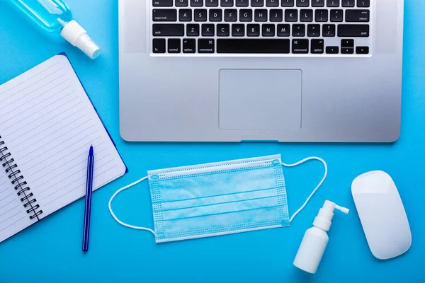 Lugar de trabajo en cuarentena con una mascarilla protectora y un cuaderno vacío para las reglas de texto en la oficina para protegerse del coronavirus. — Foto de Stock